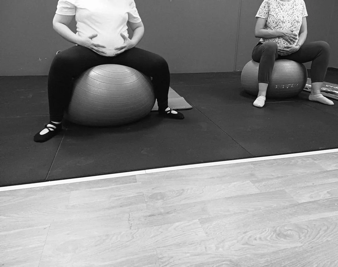 Due donne in gravidanza sedute sulla fitball durante il percorso di preparazione al parto